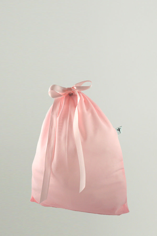 A light pink bag made of mesh fabric with a matching satin ribbon closure, By worldwide Ballet.
