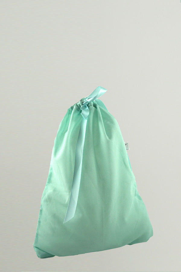 A light green small bag made of mesh fabric with a matching satin ribbon closure, By worldwide Ballet.