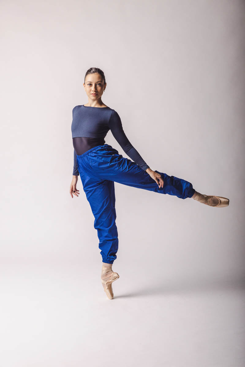 the dancer wearing Trashbag Pants, color: Royal Blue, perfect warm up pants, on top: crop top royal blue in By worldwide Ballet