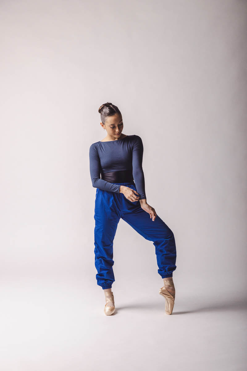 the dancer wearing Trashbag Pants, color: Royal Blue, perfect warm up pants, on top: crop top royal blue in By worldwide Ballet